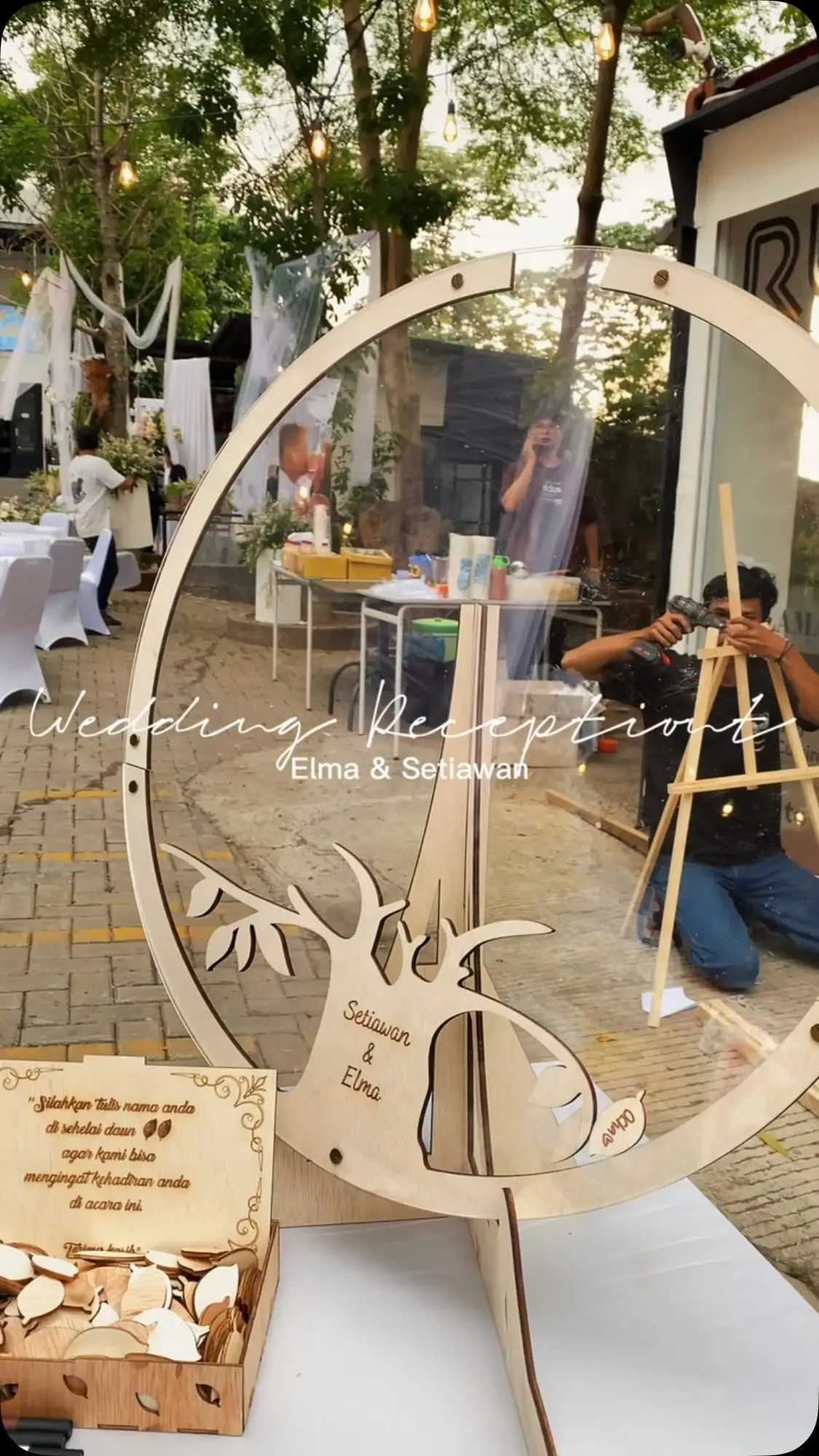 Welcome sign kayu berbentuk lingkaran bertuliskan Wedding Reception di area masuk acara